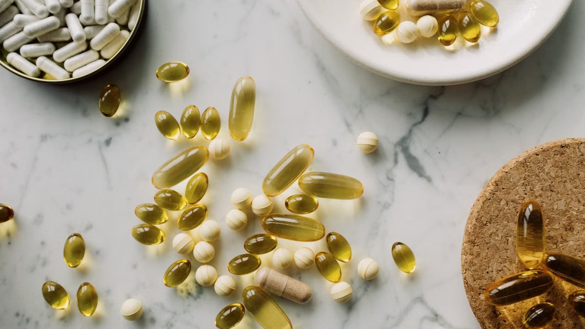A collection of supplements and pills scattered on a marble surface, showcasing healthcare essentials.